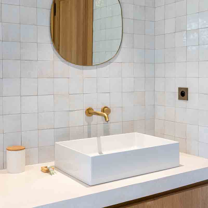 Salle de bain moderne à Marseille, vasque blanche et robinetterie laiton, photo immobilière pro par un expert en PACA.