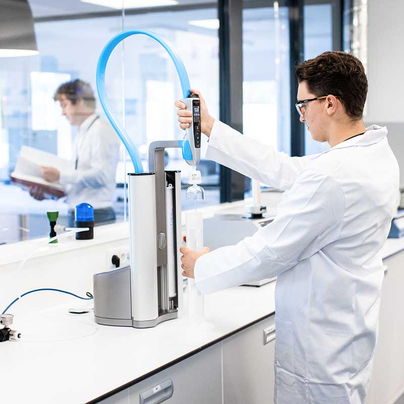 photo reportage recherche santé marseille Photo santé Marseille : chercheur en blouse blanche manipulant un automate de précision dans un laboratoire médical de Paca.