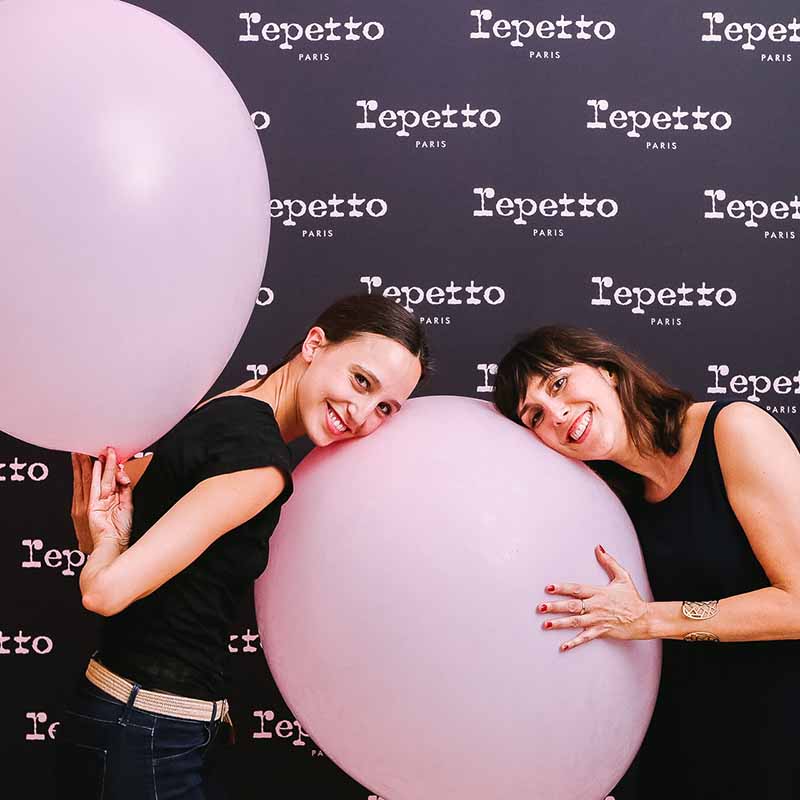 Photo événementielle Marseille : deux femmes souriantes avec de grands ballons roses lors d'un lancement de produit Repetto.