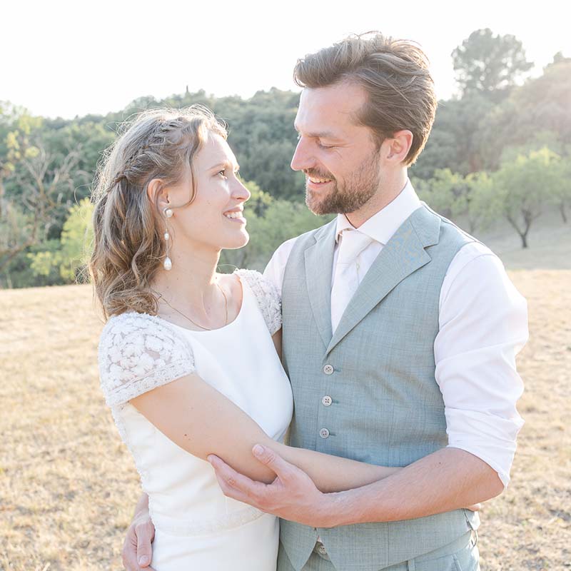 photographe mariage couple provence Mariés enlacés avec tendresse dans un champ d'oliviers en Provence lors d'une séance photo de couple au soleil couchant.