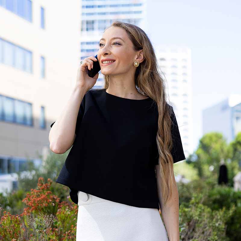 photographe portrait corporate lifestyle entreprise marseille Portrait corporate d'une femme d'affaires en tenue blanche devant un immeuble de bureaux à Marseille.