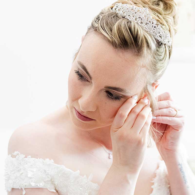 photographe préparatifs mariage Marseille Provence Gros plan d'une mariée ajustant ses boucles d'oreilles lors de ses préparatifs de mariage en Provence.