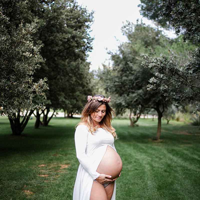 photographe séance grossesse marseille Photographe grossesse Marseille : femme enceinte avec couronne de fleurs dans un champ d'oliviers en Provence.