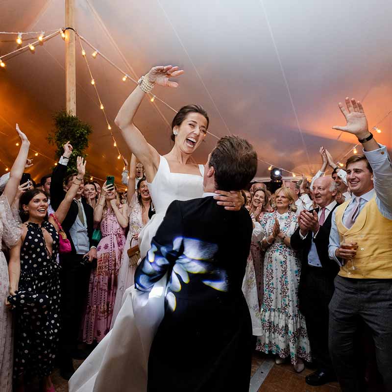 photographe soirée mariage Marseille Provence Jeune mariée portée par son époux lors d'une danse endiablée pendant la soirée de mariage en Provence.