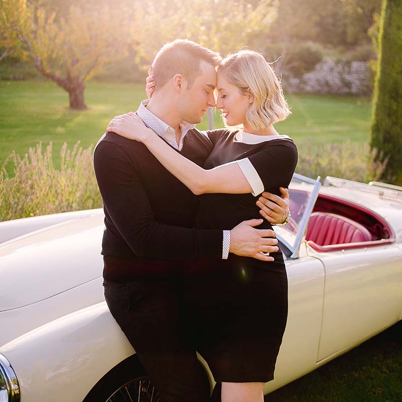 Photographe couple Marseille : amoureux enlacés contre une voiture de collection dans un parc en Provence.