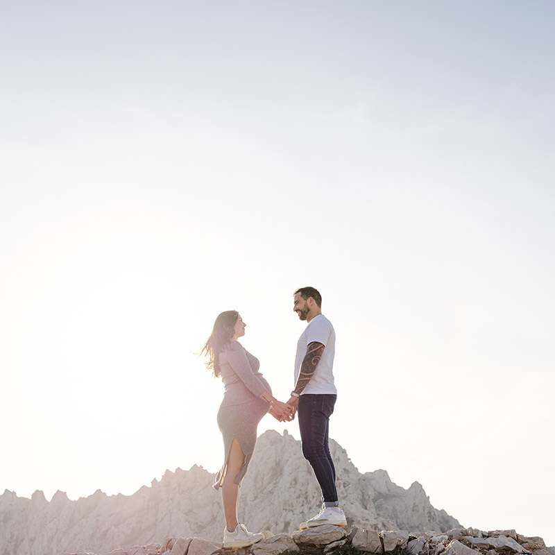 séance photo grossesse marseille Photographe grossesse Marseille : couple attendant un enfant sur une crête rocheuse face aux montagnes.